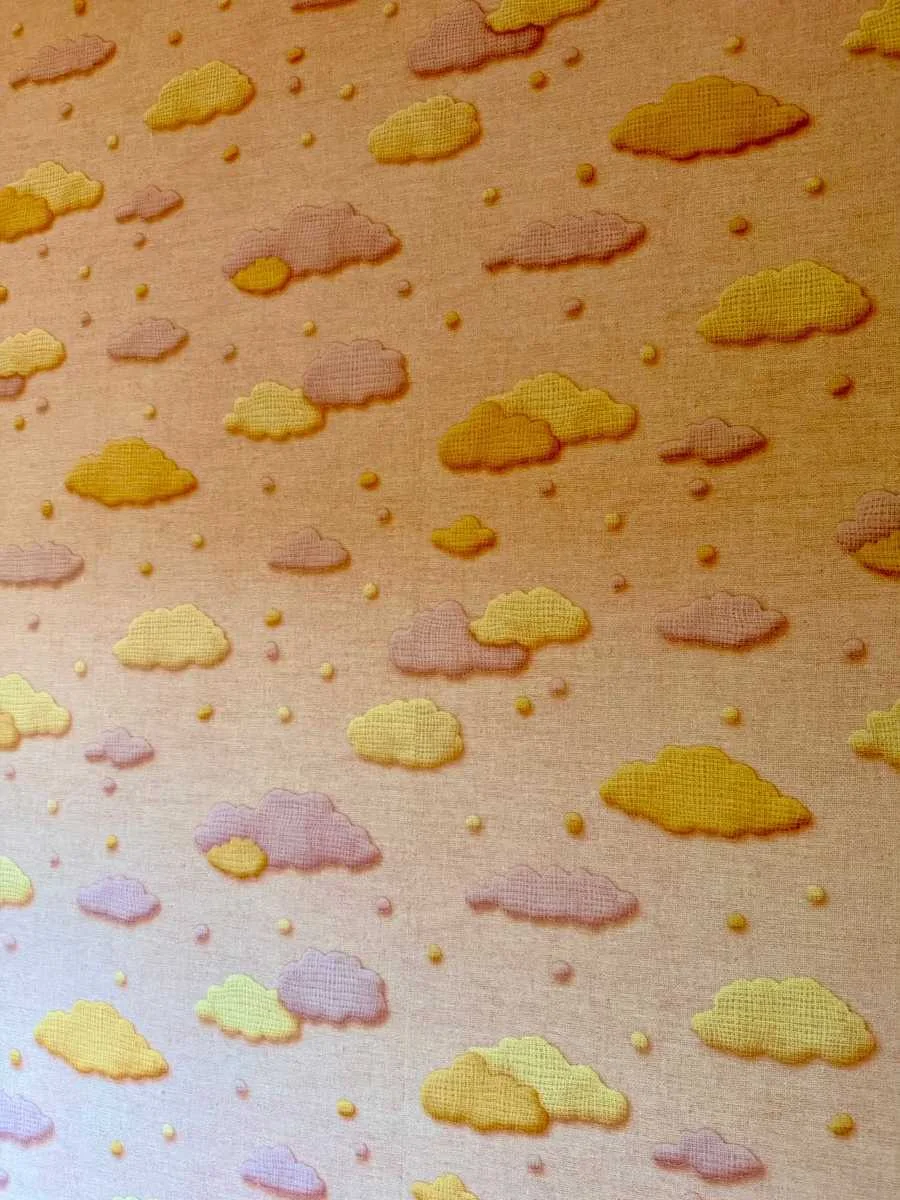 Close-up van het behang met okergele en lila wolkjes